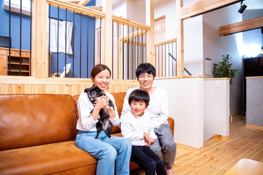 ソファに座る犬を抱いたご家族