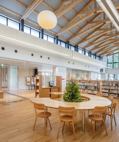 木の梁が架かる明るい図書館の内観
